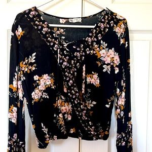 Black floral blouse with lace up tie and elastic at waist and sleeves.